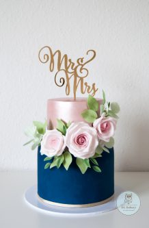 Two-tier blue and rose wedding cake with sugar roses decorations and MR. & MRS. sign